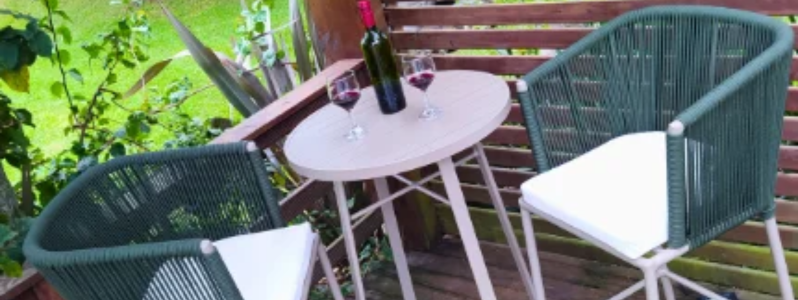 Conjunto bistrô com mesa redonda e duas cadeiras em corda náutica na varanda.